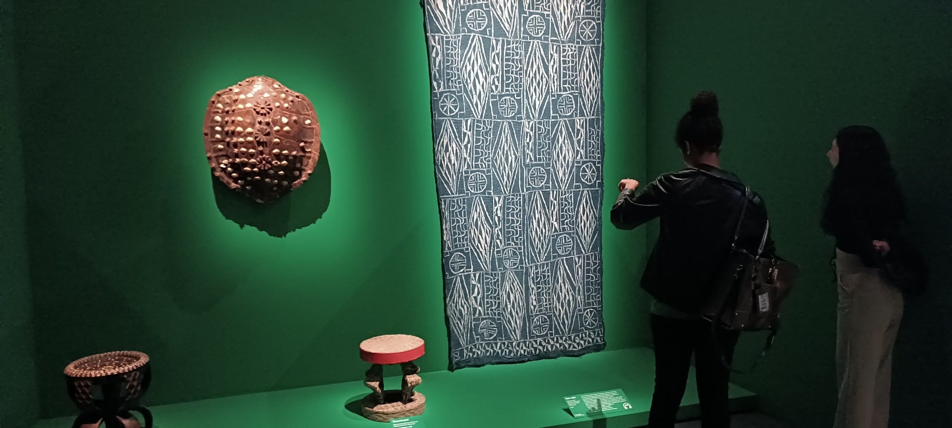 Grande tenture Ndop et masque à cauris dans la salle du musée